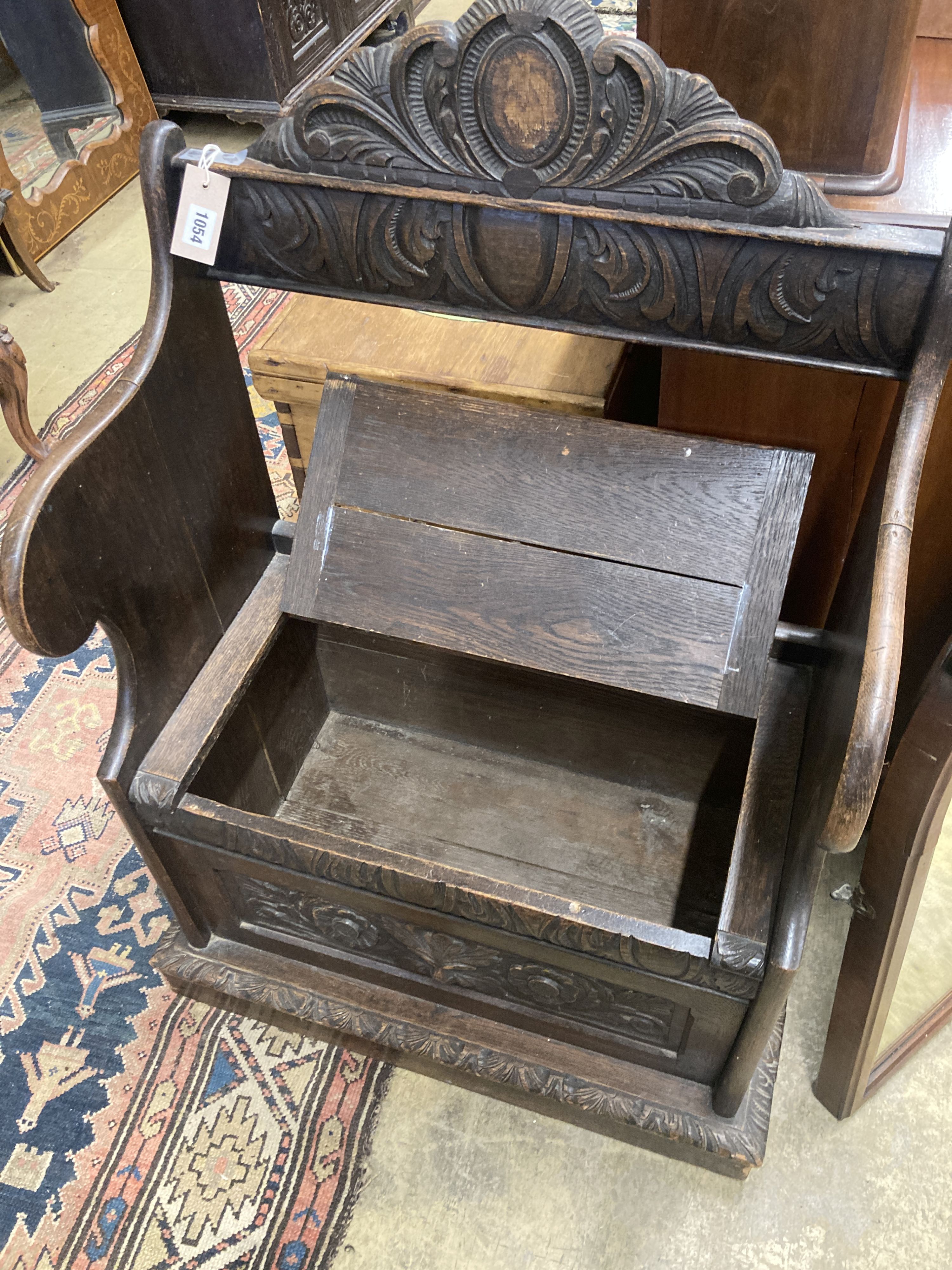 A small Flemish carved oak box seat settle, width 65cm, depth 40cm, height 104cm